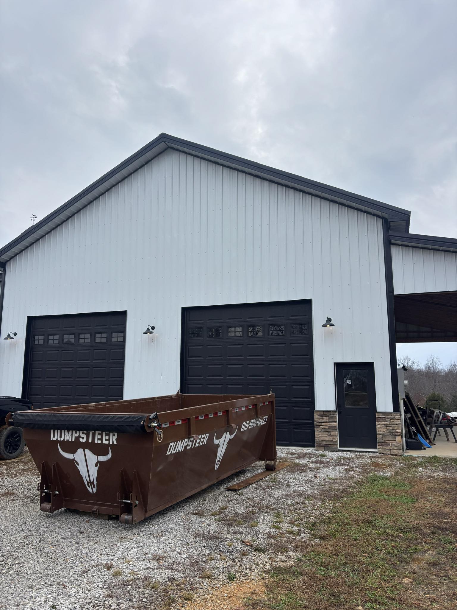 Dumpsteer dumpster at a barn job site